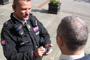 A Security Officer with a body worn camera conducts an interview