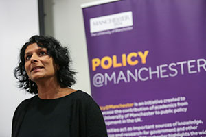 Woman standing in front of Policy@Manchester sign