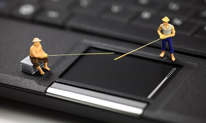 Miniature figurines on a laptop with fishing rods