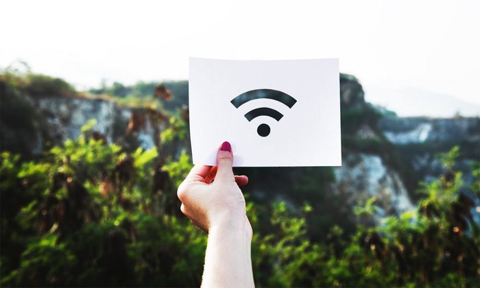 A photograph of a hand holding a Wi-Fi signal icon