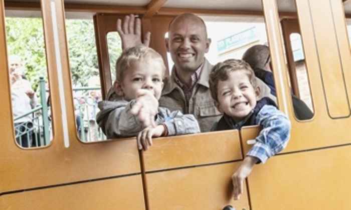 father with children on funfair ride