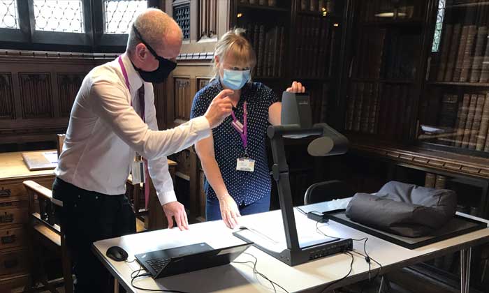 Two members of staff scanning a resource