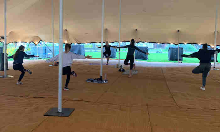 People exercising in large open tent
