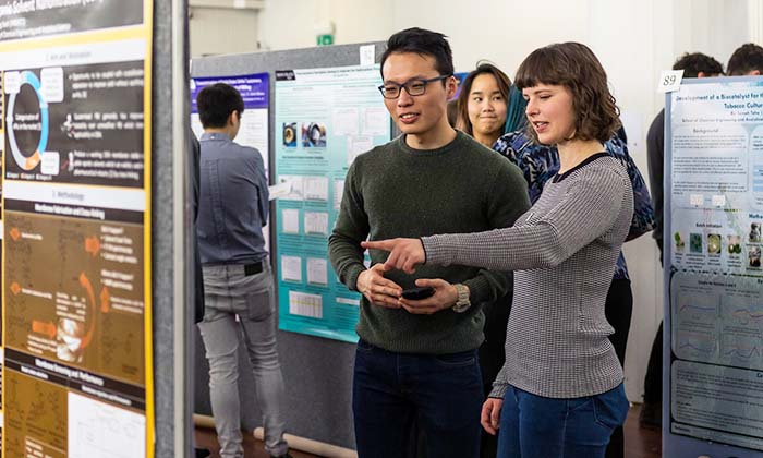 Two researchers looking at poster