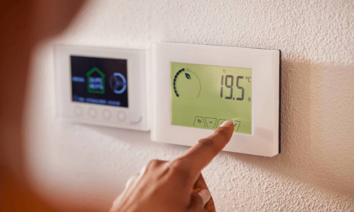 Image of woman operating a thermostat