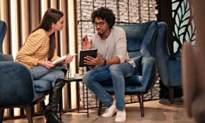 Man and woman sitting with device