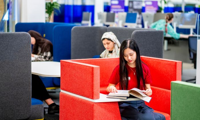 Two students in Blue Ground of Main Library reading books