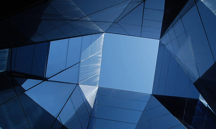 Mirrors and glass panels form an angular, kaleidoscopic chamber with a square op