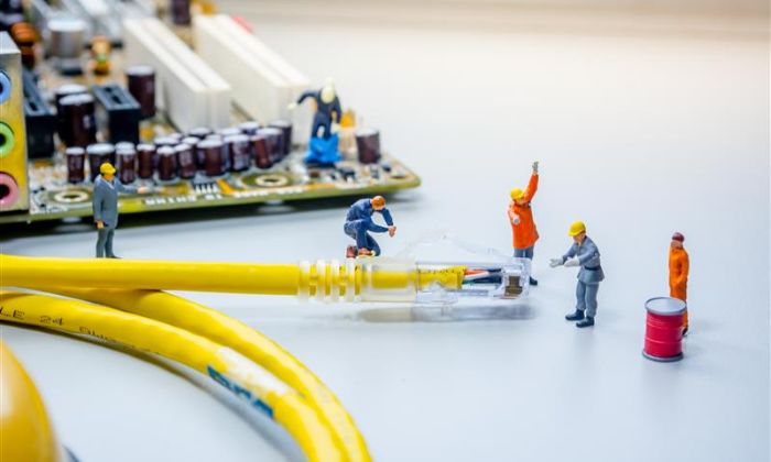image of small plastic people working on repairing computer cables