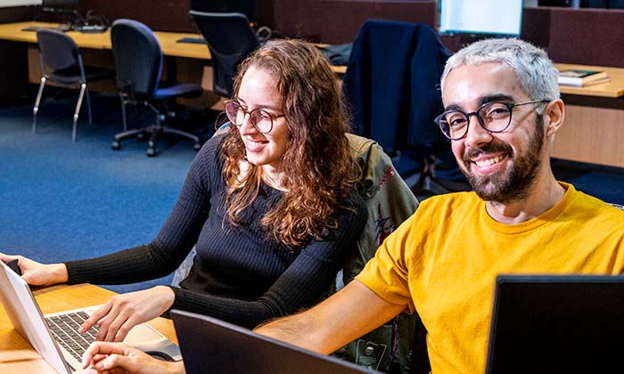 Two smiling students in the Library