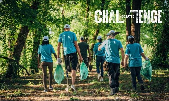adults litter picking in the forest with Challenge Accepted logo