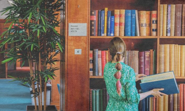 Woman in a library looking at books on a shelf
