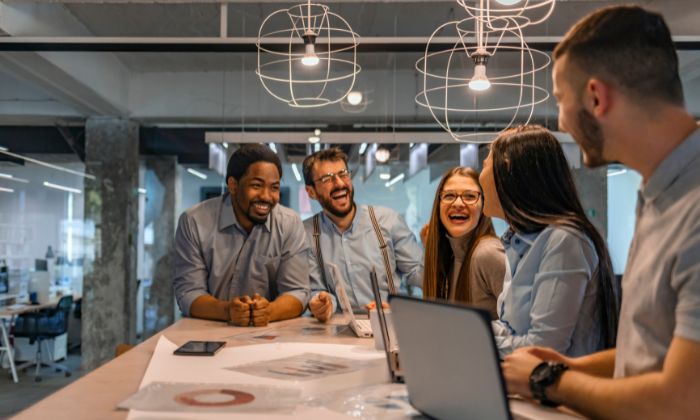 Colleagues laughing around a desk