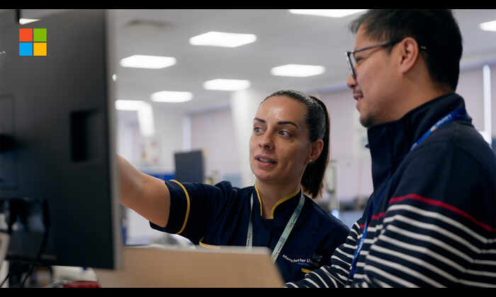 Healthcare professionals looking and pointing at a screen